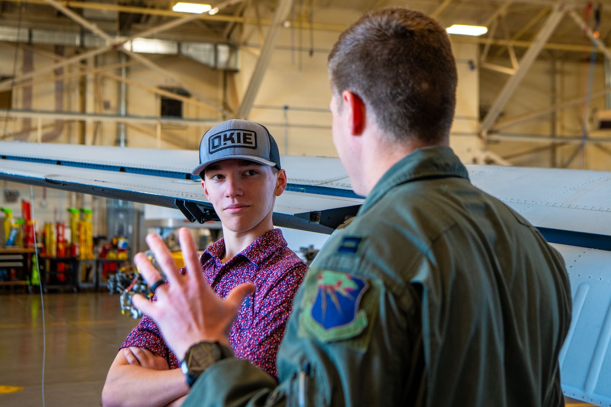 An attendee listens intently as an MC-12W pilot with the 185th Special Operations Squadron, Oklahoma Air National Guard, explains the capabilities of the aircraft during the 137th Special Operations Wing 2024 Student Flight Fest Invitational event held at Will Rogers Air National Guard Base, Oklahoma, March 28, 2024. The invitational allowed for students, educators and other visitors from across the state to broaden their understanding of what the OKANG has to offer through aircraft displays, interactive stations, and discussions with Airmen and Soldiers from diverse career fields.