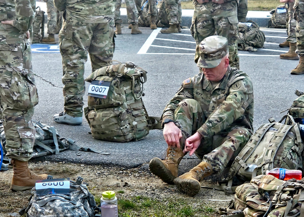 Master Sgt. Kenneth Boff of Joint Force Headquarters, New Hampshire Army National Guard, laces up before the 18.6-mile Norwegian Foot March May 4, 2024, in Concord, N.H. Boff was one of 39 of 61 competitors to complete the event in the prescribed time, finishing in about 4:24:00 while pushing through cramps, blisters and dehydration.