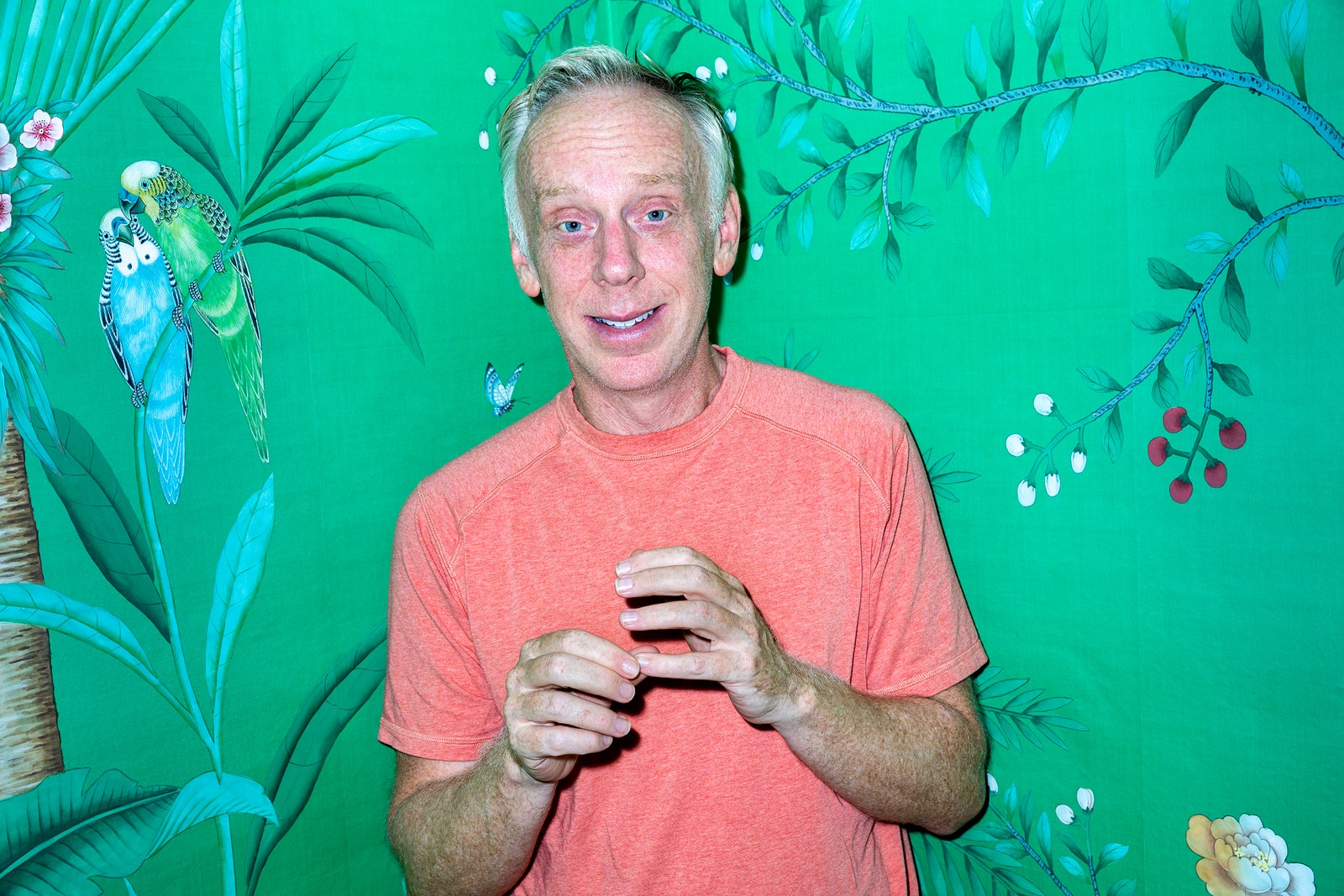 Actor Mike White in front of tropical wall paper.