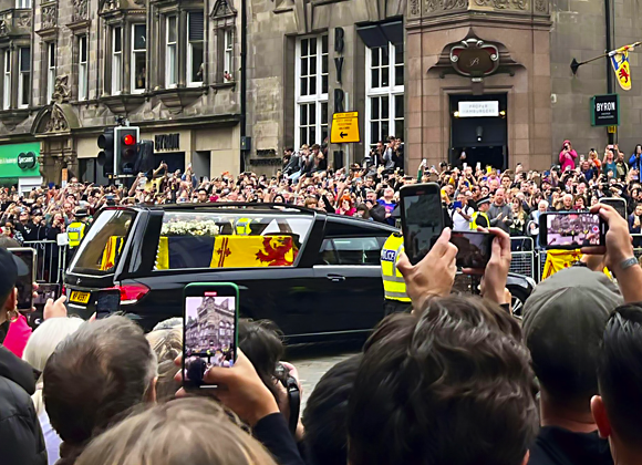Crowds gather on the streets of Edinburgh to watch the hearse carrying the coffin of Queen Elizabeth II on 11th September. Image: Newscom / Alamy Stock Photo 