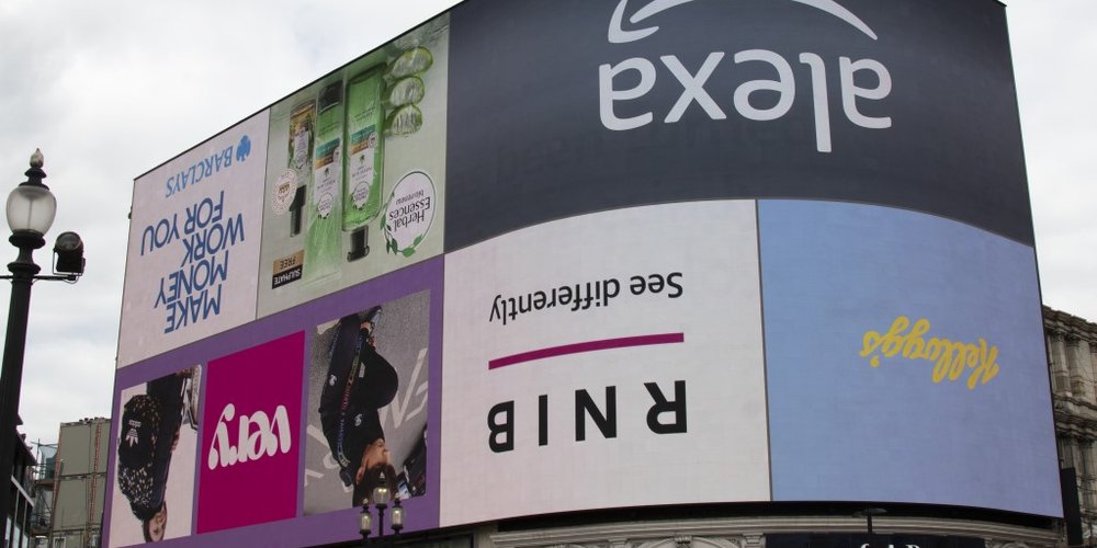 A building at Piccadilly Lights with adverts turned upside down as part of RNIB's #WorldUpsideDown campaign