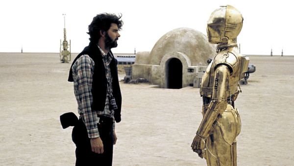 Schöpfer und Werk, Auge in Auge: Regisseur George Lucas und der Droide C3PO (Anthony Daniel) am Set in Tunesien im Jahr 1976