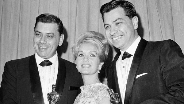 1965 wurde Richard M. Sherman (r.) zusammen mit seinem Bruder Robert (l.) mit einem Oscar für die beste Filmmusik ausgezeichnet. Zwischen ihnen die  Schauspielerin Debbie Reynolds, die ihnen die Trophäen für den Film „Mary Poppins“ überreicht hat.