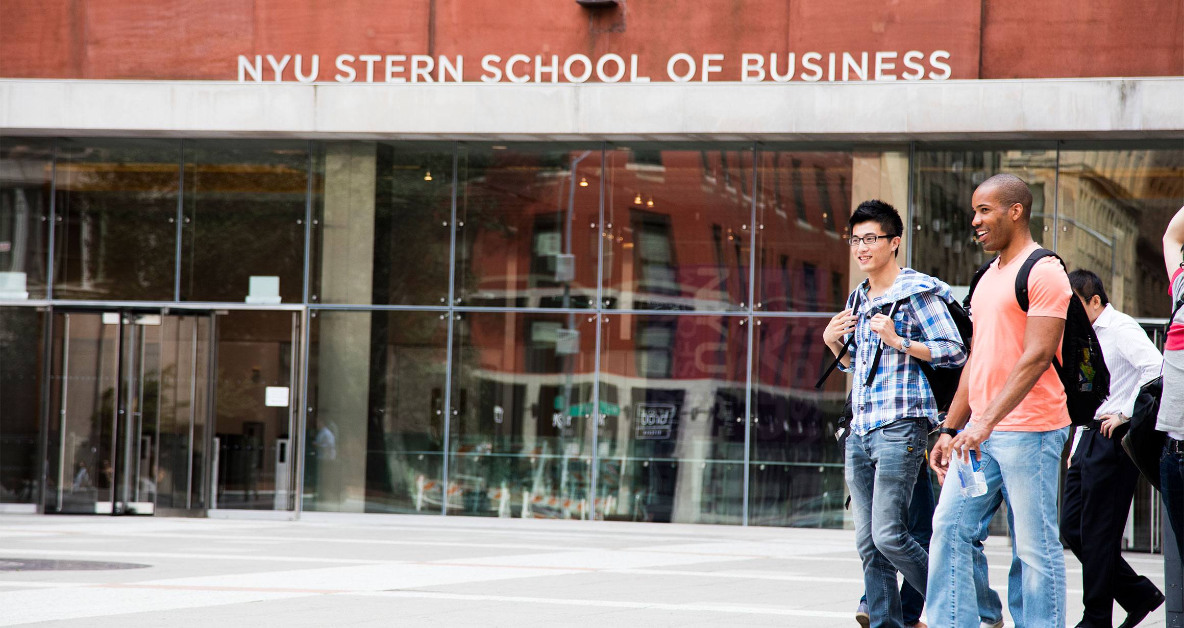 Students walk through Gould Plaza passing the Stern School of Business