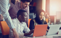 Four people looking at laptop screen