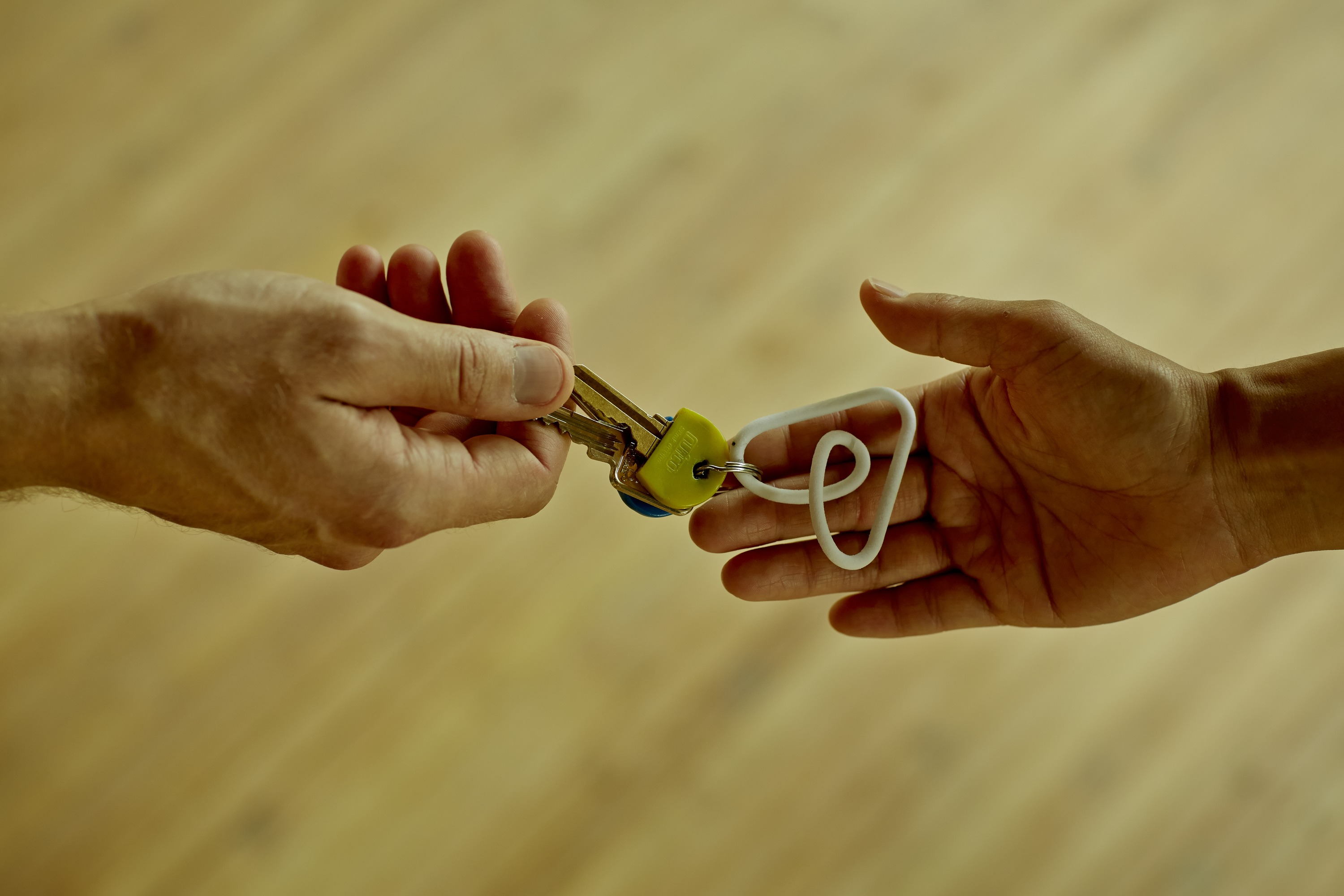 A hand putting a key into another hand