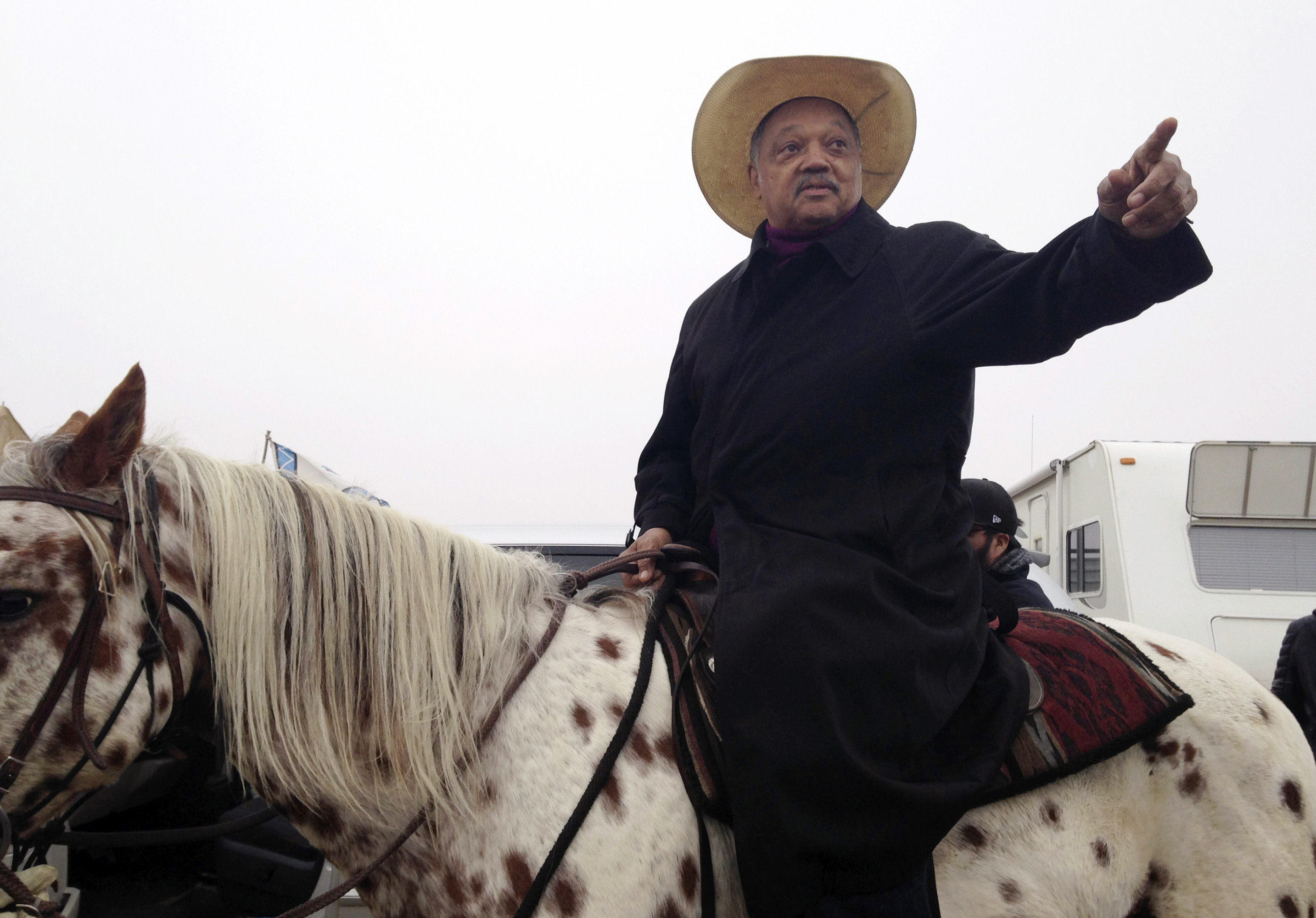 Civil rights activist Jesse Jackson sits atop a horse.