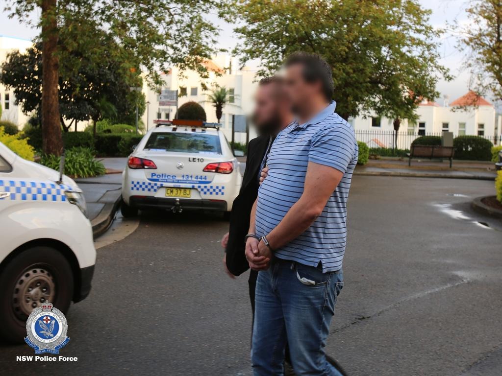Scott Miller, former butterfly champion, now 49, in handcuffs on a city street after being arrested in 2020 for involvement in a Sydney meth ring.