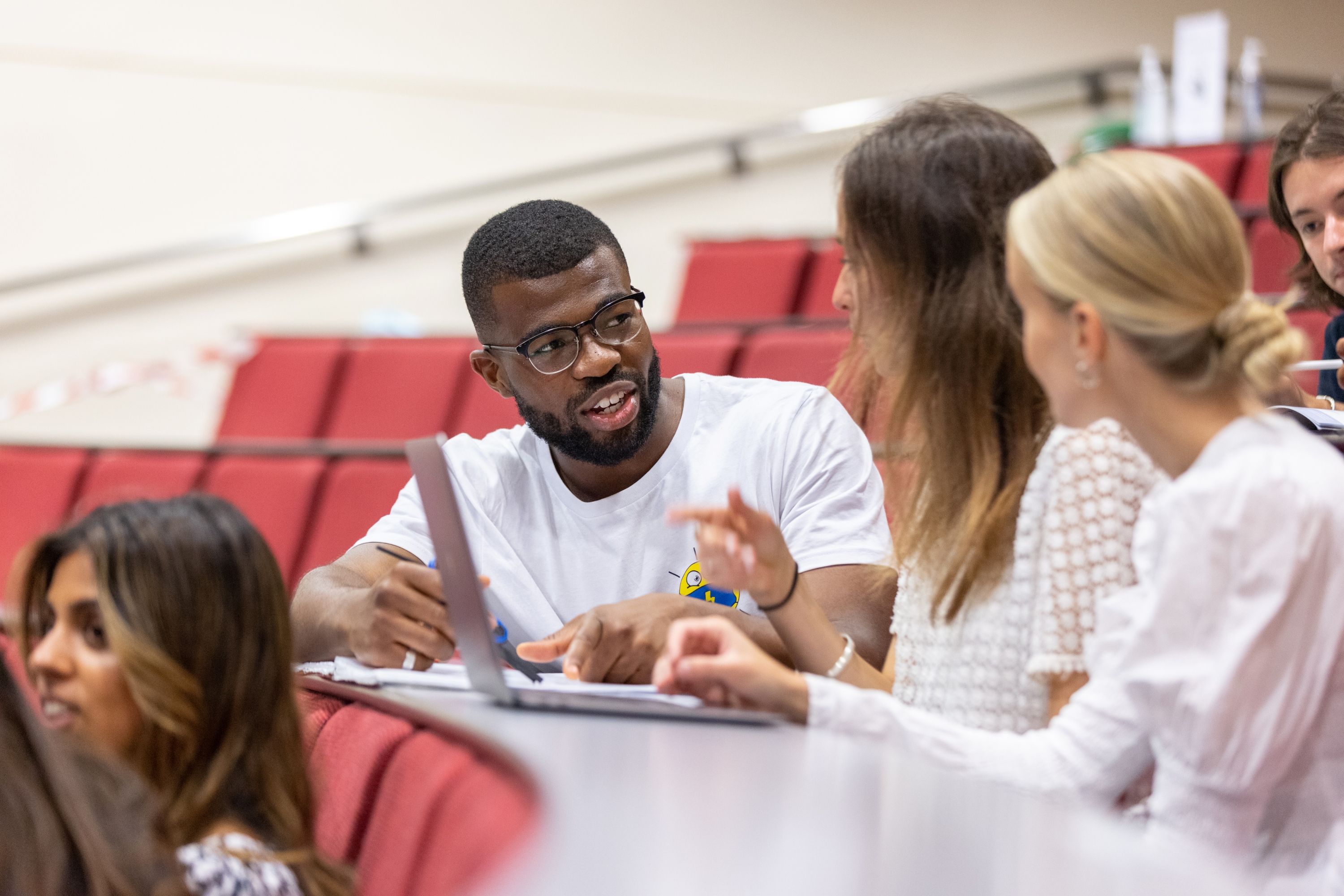 Three students in a lecture theatre