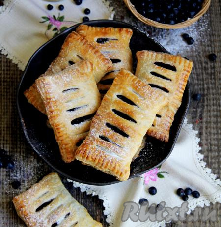 Аппетитные слойки с сочной начинкой из черники достать из духовки, переложить на тарелку, дать немного остыть, по желанию, присыпать сахарной пудрой и подать к столу. Очень вкусно получилось!