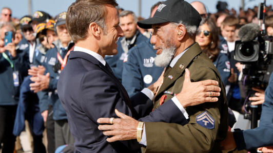 Le président français Emmanuel Macron décerne la Légion d'honneur à Arlester Brown, vétéran américain de la Seconde Guerre mondiale, lors de la cérémonie internationale à Omaha Beach marquant le 80e a