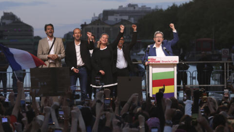 Far-left La France Insoumise - LFI - (France Unbowed) founder Jean-Luc Melenchon, right, clenches his fist with other party members after the second round of the legislative elections Sunday, July 7,