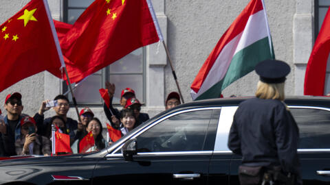 People wave Chinese and Hungarian flags for the Chinese President Xi Jinping outside the Buda Castle in Budapest, Hungary on Thursday, May 9, 2024.
