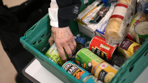 Une personne saisit une boite de conserve dans une banque alimentaire à Hackney, au nord-est de Londres (Royaume-Uni), le 31 octobre 2022