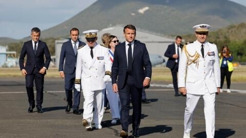 الرئيس الفرنسي إيمانويل ماكرون (في الوسط) يسير إلى جانب المفوض السامي الفرنسي في كاليدونيا الجديدة، لويس لو فرانك (الثالث على اليسار) عند وصوله إلى مطار نوميا - لا تونتوتا الدولي، في نوميا، إقليم كاليدونيا الجديدة الفرنسي في المحيط الهادئ في 23 أيار/ مايو 2024. 
