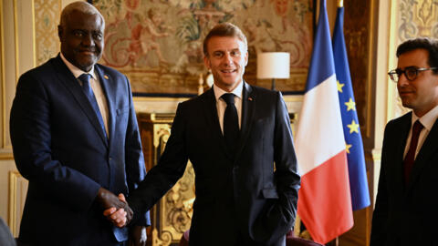 African Union Commission chair Moussa Faki Mahamat (L) shakes hands with French President Emmanuel Macron, who is standing next to French Foreign Minister Stéphane Séjourné, in Paris on June 20, 2024.