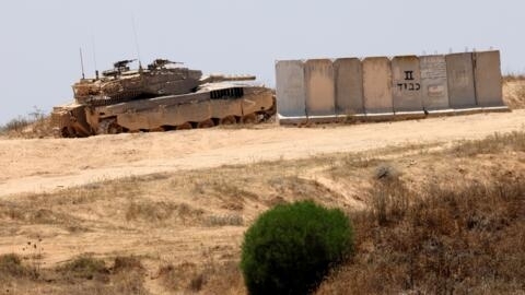 An Israeli army tank takes up position in an area of ​​Israel's southern border with the Gaza Strip, June 13, 2024.