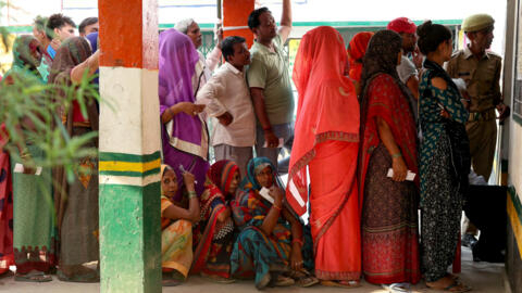Voters queue to cast their votes at a polling station in Prajapatipur village, Bhadohi district in India's Uttar Pradesh state on May 25, 2024.