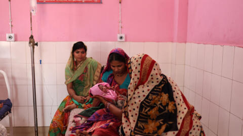 Zamerun Nisha, 33, holds her newborn baby as her sister Sanerum, 38, and her sister-in-law Zabinad, 15, keep her company at the maternity ward of a community health centre in Bahadurganj subdivision of Kishanganj district, in the state of Bihar, India, March 21, 2023.