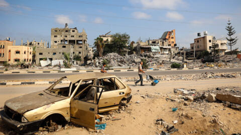 Palestinian men walk past damaged buildings after an overnight Israeli strike in al-Bureij camp in the central Gaza Strip on June 3, 2024.