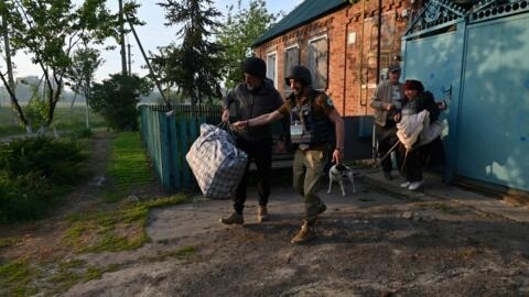 Ukrainian volunteers assit residents of settlements in the north of the Kharkiv region during their evacuation on May 10, 2024.
