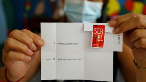 A poll worker shows the presidential election ballot at a polling station, in Santiago, Chile, on December 19, 2021.