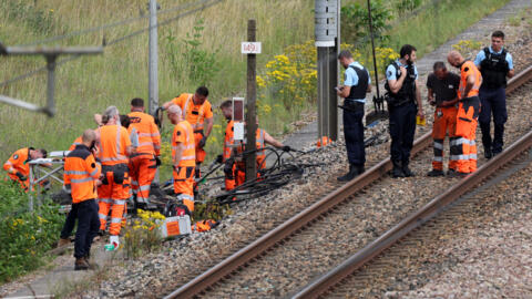 Des employés de la SNCF et des gendarmes français inspectent les lieux d'une attaque présumée sur le réseau TGV à Croiselles, dans le nord de la France, le 26 juillet 2024.