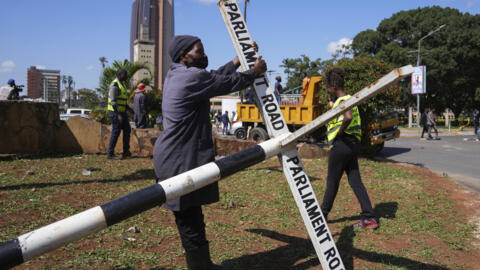 Nairobi county staff repair a street sign in downtown Nairobi, Kenya, Wednesday, June 26, 2024.