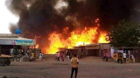 رجل يقف بينما تشتعل النيران في منطقة سوق للماشية في الفاشر، عاصمة ولاية شمال دارفور السودانية، في 1 سبتمبر/أيلول 2023