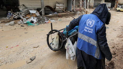 رجل يرتدي سترة وكالة الأمم المتحدة لإغاثة وتشغيل اللاجئين الفلسطينيين (الأونروا) في جنين بالضفة الغربية 30 يناير 2024.
