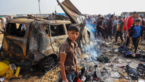 People gather at the site of a night strike that set fire to tents occupied by displaced Palestinians in a camp in Rafah, Gaza Strip, May 27, 2024