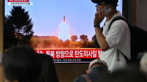 A man walks past a television screen showing a news broadcast with file footage of a North Korean missile test, at a train station in Seoul on July 1, 2024. 