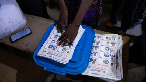 A woman counts votes at a polling station at the Abena school in N'Djamena on May 6, 2024 during Chad's presidential election. 