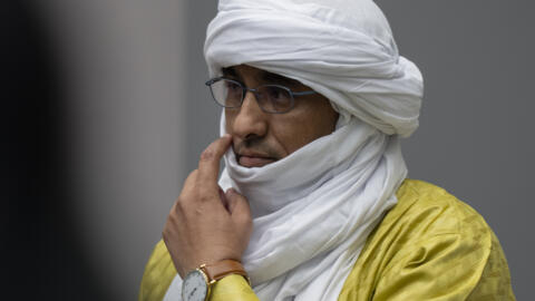 Al Hassan Ag Abdoul Aziz Ag Mohamed Ag Mahmoud se lève alors que les juges entrent dans la salle d'audience de la CPI à La Haye, aux Pays-Bas, le 26 juin 2024.