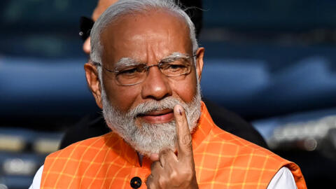 Le Premier ministre indien, Narendra Modi, montre son index taché d'encre après avoir voté aux élections générales, le 7 mai 2024 à Ahmedabad.