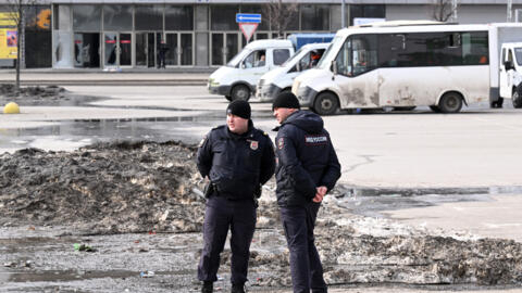 ضباط شرطة يقفون للحراسة أمام قاعة الحفلات الموسيقية المحترقة كروكوس سيتي في كراسنوغورسك، خارج موسكو، في 26 آذار/مارس 2024. 