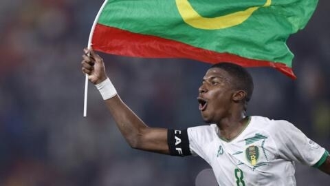 Mauritania's midfielder #8 Bodda Mouhsine holds a Mauritania flag after his team won the Africa Cup of Nations (CAN) 2024 group D football match between Mauritania and Algeria at Stade de la Paix in B