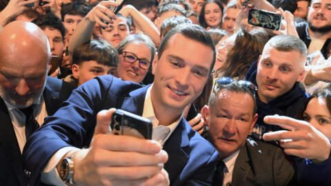 Jordan Bardella poses for a selfie with supporters during a campaign rally for the European elections in Montbeliard, eastern France, on March 22, 2024.