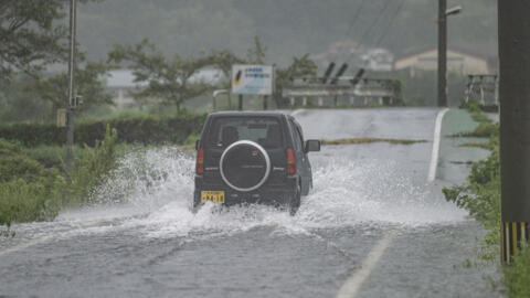 A car drives through a flooded street in Yufu city of Oita prefecture on August 29, 2024. Typhoon Shanshan, one of Japan's strongest typhoons in decades, dumped torrential rain across southern regions