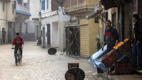 Un jeune homme arpente à vélo et sous la pluie les rues de Fnideq, au Maroc, le 5 mars 2021.