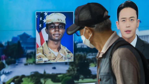 In this fphoto taken in Seoul on August 16, 2023, a man walks past a television showing a news broadcast featuring a photo of US soldier Travis King.