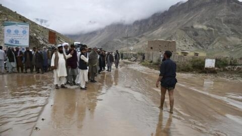 أفغان يتجمعون في طريق في ولاية سمنكان في أفغانستان بعد فيضانات مفاجئة في 11 أيار/مايو 2024