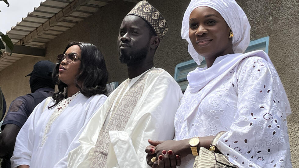 Senegal's president-elect Bassirou Diomaye Faye (C) with his wives Marie Khone Faye (L) and Absa Faye (R)
