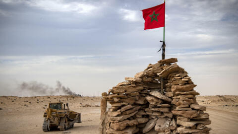 Un bulldozer passe près d'une colline gardée par des soldats marocains sur une route entre le Maroc et la Mauritanie à Guerguerat, dans le Sahara occidental, le 23 novembre 2020.