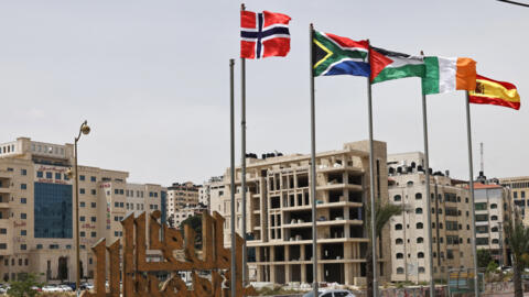 The flags of Norway, South Africa, Palestine, Ireland and Spain are raised at an entrance of Ramallah city in the occupied West Bank on May 28, 2024.