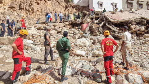 Des membres des Forces auxiliaires et de la Protection civile recherchent des personnes disparues dans les décombres d'une zone dévastée par les inondations à Tamanart, le 8 septembre 2024.