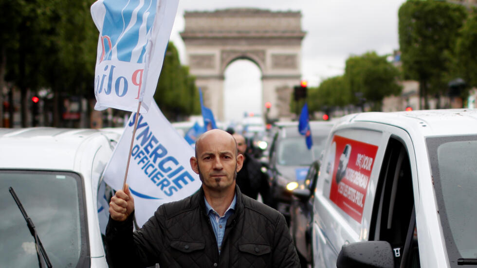 ضابط بوليس فرنسي يتظاهر على جادة الشانزليزيه احتجاجا على منع أسلوب تقييد الرقبة لاحتجاز المشتبه بهم. الجمعة 12 يونيو/حزيران 2020.