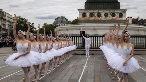 File photo: Lead dancer of the Opera de Paris Hugo Marchand holds the olympic torch in front of the Opera de Paris dancers at Place de la Bastille in Paris on July 14, 2024.