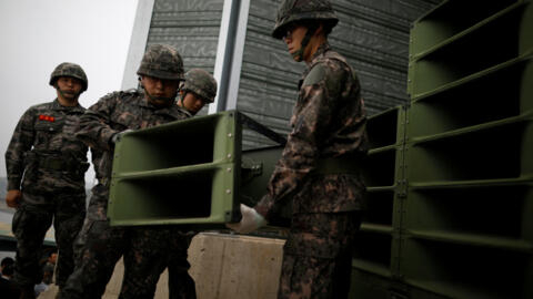 Des soldats sud-coréens démontent des haut-parleurs près de la zone démilitarisée en 2018. 