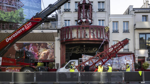 Workers prepare to install one of four new windmill sails at Paris's Moulin Rouge cabaret club.